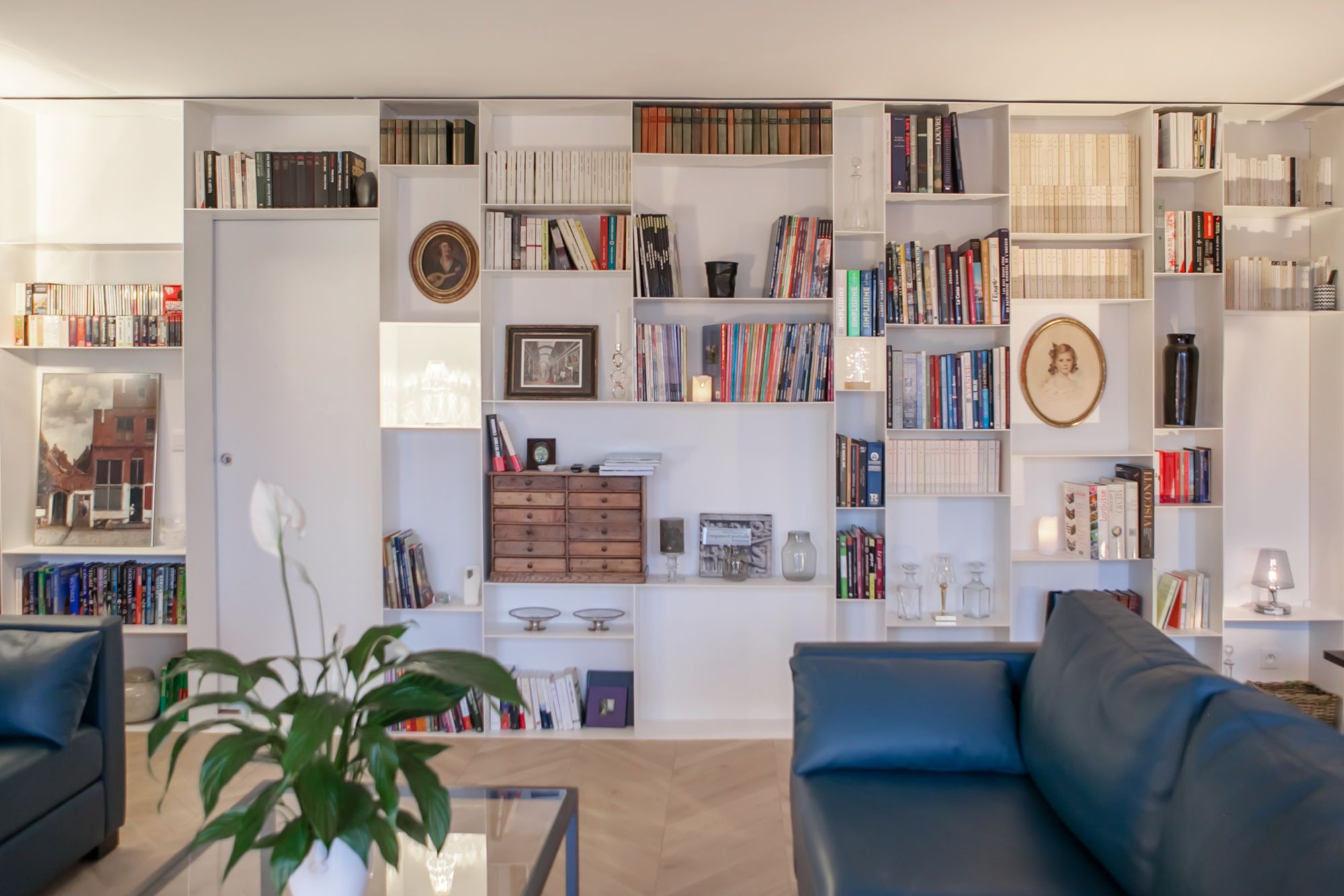 Salon avec canapé en cuir et bibliothèque sur-mesure